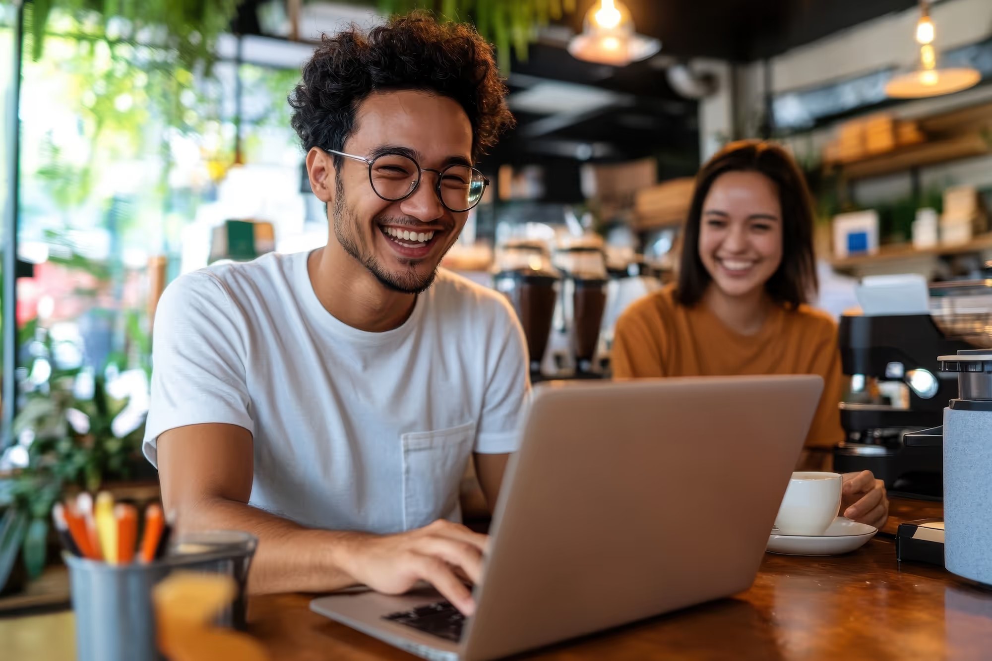 Zwei Personen arbeiten im Café am Laptop
